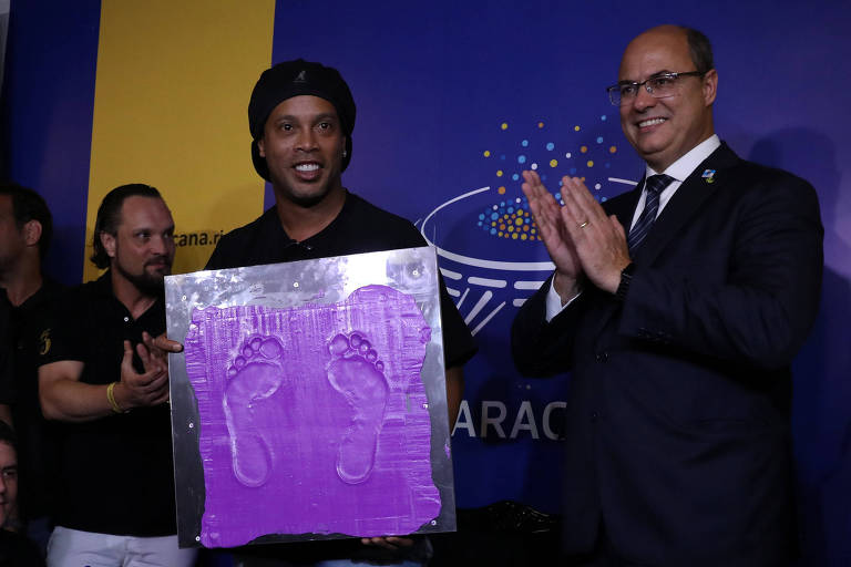 Ronaldinho segura marca com formato de seus pés