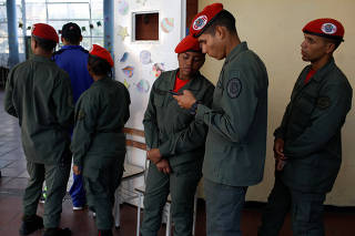 Venezuelan soldiers wait to cast their votes at a polling station during the municipal legislators election in Caracas