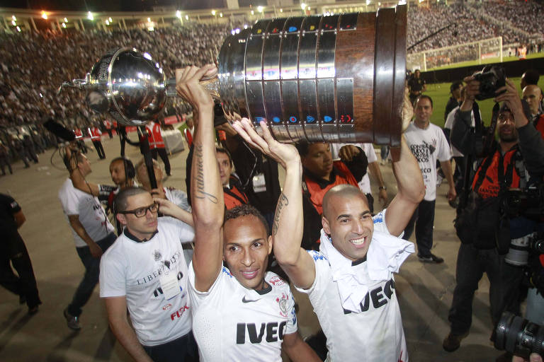 Lideson (esq.) e Emerson Sheik carregam a taça de campeão da Libertadores