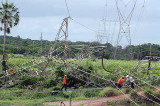 Technicians work on the site where a power transmission tower was damaged by a bomb in the outskirts of Fortaleza