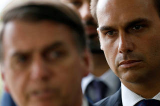 Eduardo Bolsonaro, son of Brazil's President-elect Jair Bolsonaro is seen behind him at the transition government building in Brasilia