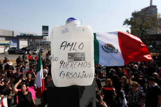 People take part in a protest against fuel shortages near a gas station in Guadalajara
