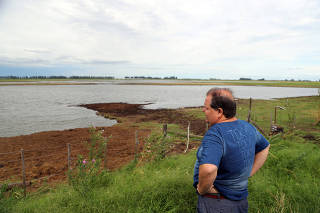Farmer Giustocio stands in a field that had been used to plant soy and was affected by recent floods near Norberto de la Riestra