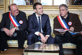 French President Emmanuel Macron sits next to Vanik Berberian, president of AMRF and General Secretary of AMRF Michel Fournier during a meeting in Paris