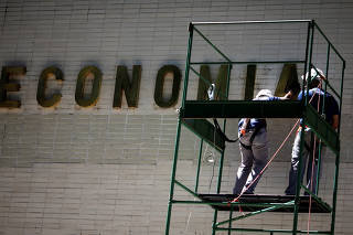 Employees install name-plate of the Ministry of the Economy at the old Ministry of Labour and Employment building in Brasilia