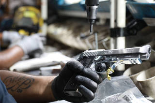 An employee from gun manufacturer Taurus Armas SA works at the company's assembly line in Sao Leopoldo