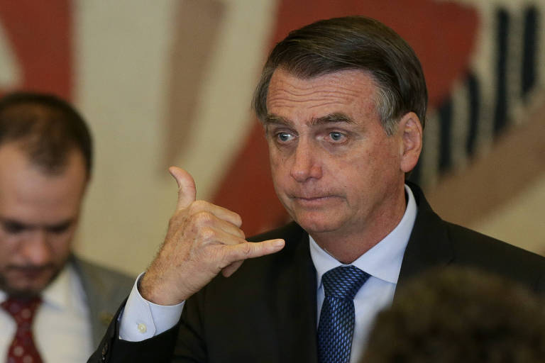 O presidente Bolsonaro faz gesto semelhante a um cumprimento de surfista durante recepção ao argentino Macri