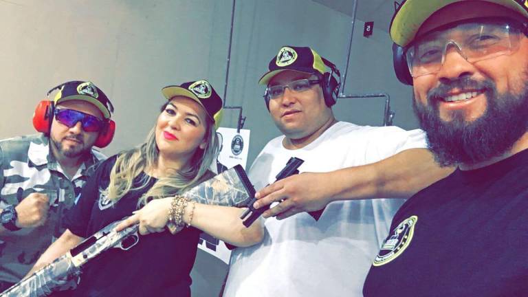 A empresária Solange Lopes, 39, ostenta arma com amigos