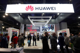 FILE PHOTO: Attendees pass by a Huawei booth during the 2019 CES in Las Vegas