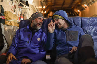 Colin O?Brady, right, and Louis Rudd share stories after they each completed solo unassisted treks across Antarctica, on a flight back to Punta Arenas, Chile.