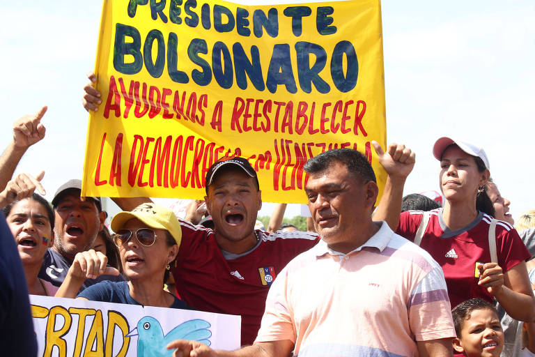 Imigrantes venezuelanos em Boa Vista protestam em apoio a manifestação convocada na Venezuela pela oposição; cartaz pede ajuda de Bolsonaro para restabelecer a democracia no país vizinho