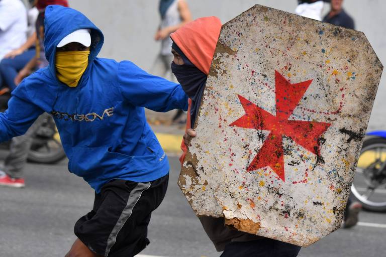 Manifestantes de oposição usam escudo em confronto com a polícia 