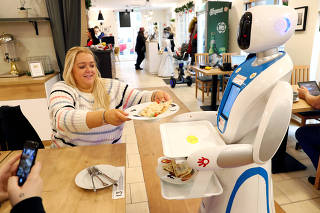 A robot waiter serves customers at a cafe in Budapest