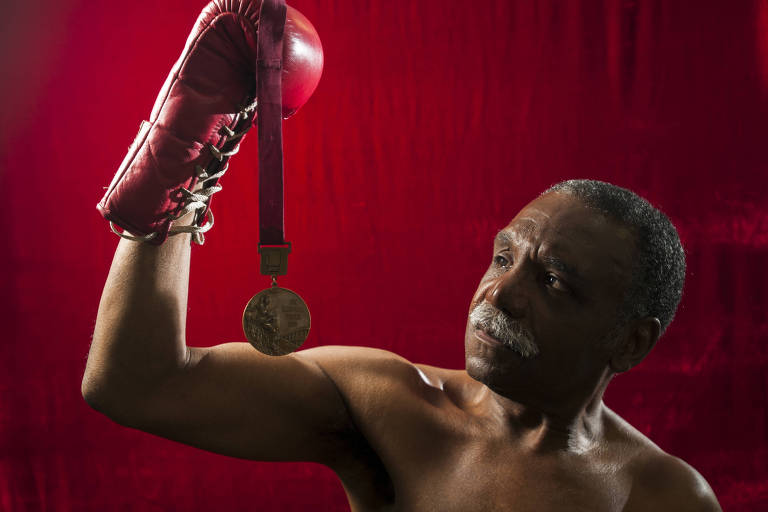 O ex-boxeador Servílio de Oliveira segura a medalha de bronze conquistada nos Jogos de 1968, na Cidade do México