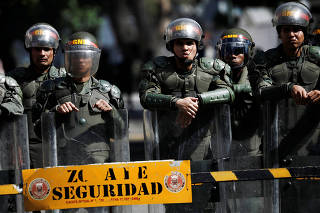 Security forces guard the entrance of a military building in downtown Caracas, Venezuela