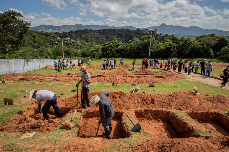 Coveiros e voluntários trabalham na abertura de novas covas em Brumadinho (MG)