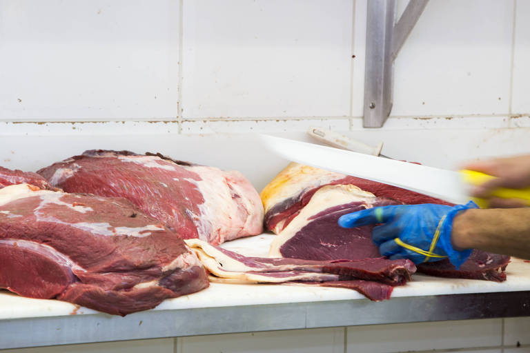 Açougueiro manipula peças de carnes, no bairro da Saúde, em São Paulo (SP)