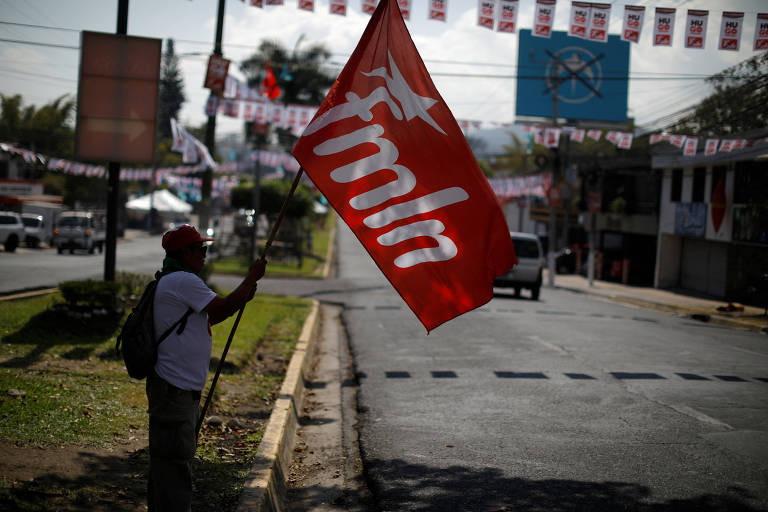 Apoiador do candidato esquerdista Hugo Martínez, da FMLN, do lado de fora de local de votação em San Salvador