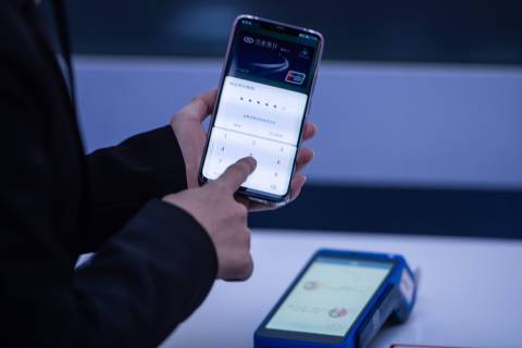 A hostess displays how to use the new Huawei smarthone pay service during a press conference and launch of new 5G Huawei products at the Huawei Beijing Executive Briefing Centre in Beijing on January 24, 2019. (Photo by FRED DUFOUR / AFP)