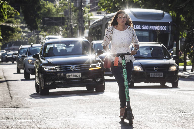 Mulher anda de patinete na rua Tabapuã