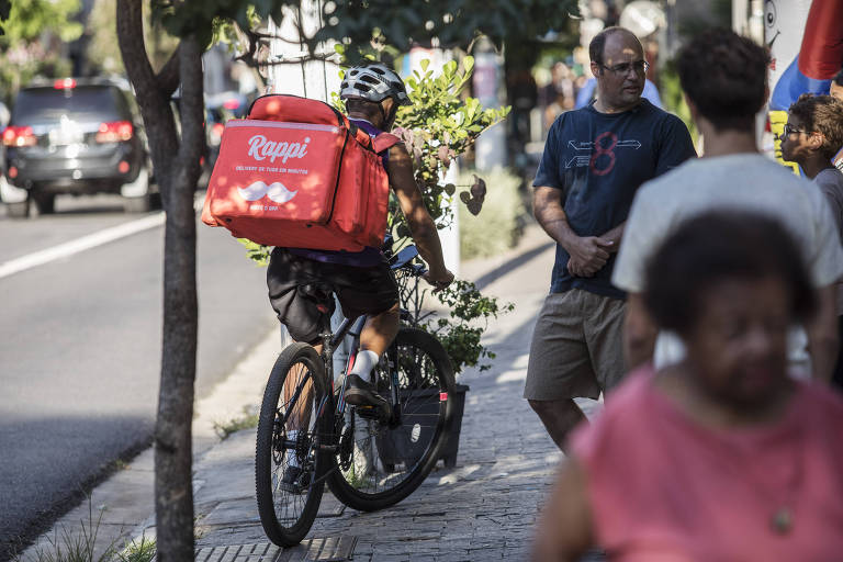 Entregador da Rappi circula de bicicleta na calçada da rua Tabapuã, no Itaim Bibi