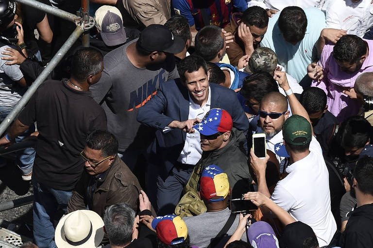 O líder da oposição Juan Guaidó (ao centro, de terno) chega à manifestação contra a ditadura de Maduro