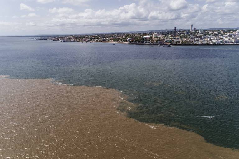 Encontro das águas do rio Amazonas (marrom) e o rio Tapajós (azul), com a cidade de Santarém ao fundo