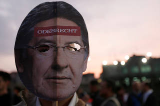 A protester wears a mask with the face of Nestor Humberto Martinez, the Colombian Attorney General, during a protest against his alleged links to the Odebrecht scandal in Bogota