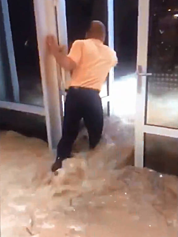Funcionário do hotel Sheraton tenta fechar a porta devido o alagamento