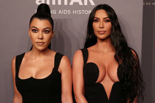 Kim Kardashian and her sister Kourtney Kardashian pose on the red carpet for the amfAR gala in New York