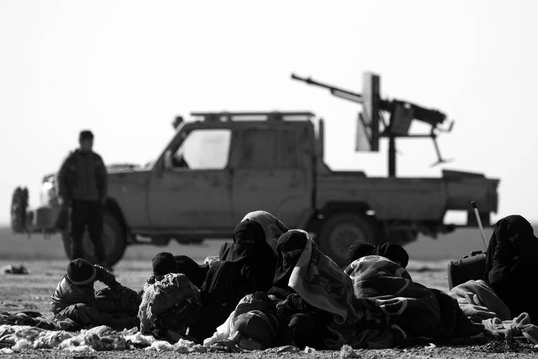 Sírios próximos a veículo das forças do governo em Baghuz, fronteira com o Iraque
