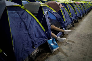 Internet user rests inside his tent at the camping area of the Campus Party event in Sao Paulo