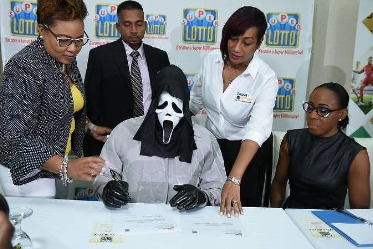 Ganhador de loteria usa mÃ¡scara do PÃ¢nico para receber prÃªmio na Jamaica
