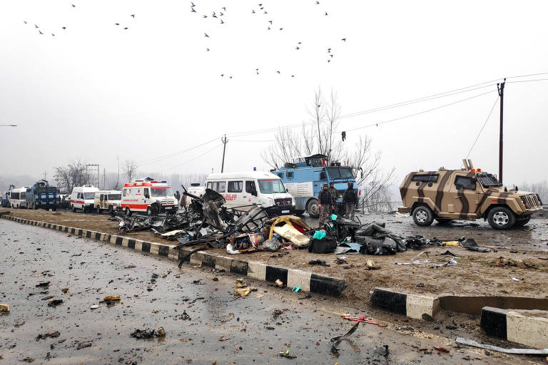 Soldados indianos examinam os destroços depois de uma explosão em Lethpora, na Caxemira do Sul, na Índia