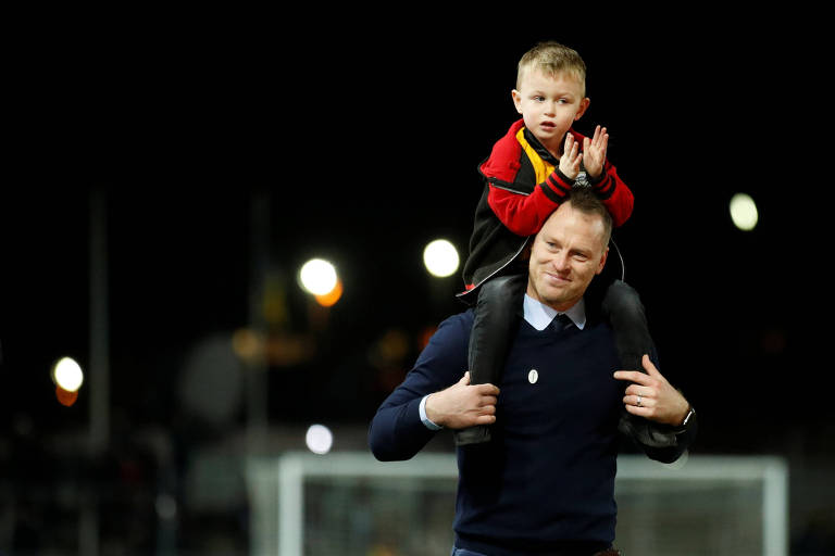 Michael Flynn carrega o filho nos ombros e festeja a vitória sobre o Leicester, pela Copa da Inglaterra