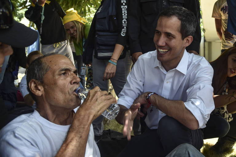 O líder da oposição venezuelana e autodeclarado presidente em exercício, Juan Guaido (D) saúda os voluntários do movimento "Coalizão Venezuela e Ajuda à Liberdade"