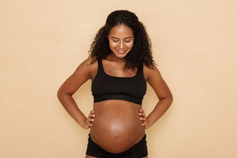 Mulher mostra a barriga de grávida