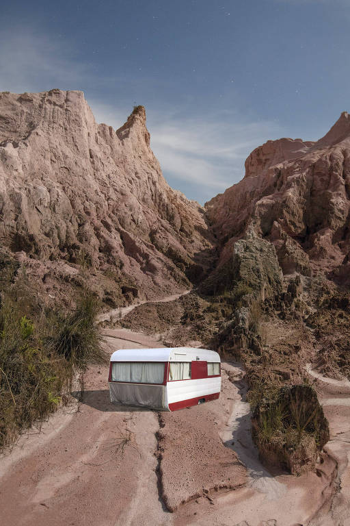 Um trailer vermelho e branco entre rochas