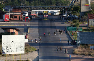 People walk on a street as they cross the border from Venezuela to Brazil in Pacaraima