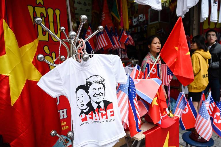 Vendedor espera por clientes, enquanto exibe camisetas com imagens do presidente dos EUA, Donald Trump, e do ditador da Coréia do Norte, Kim Jong Un, em Hanói