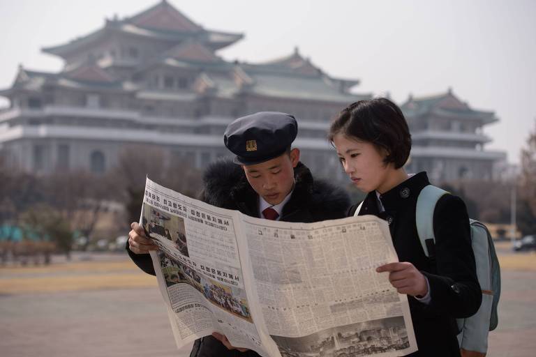 Estudantes norte-coreanos leem o jornal Rodong Sinmun, que mostra o ditador norte-coreano Kim Jong Un chegando ao Vietnã antes da cúpula com o presidente dos EUA, Donald Trump