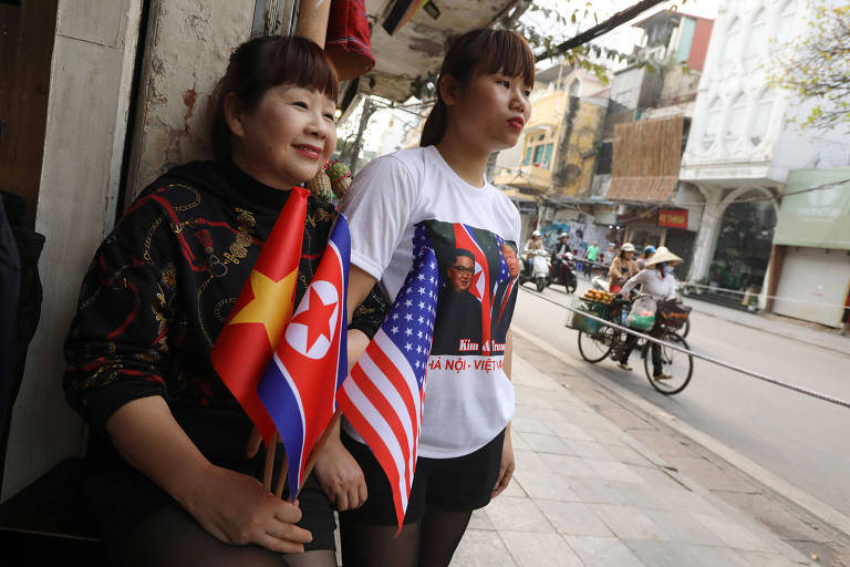 Mãe e filha com as bandeiras dos EUA, Vietnã e Coréia do Norte e uma camiseta com os rostos do ditador norte-coreano Kim Jong Un e do presidente dos EUA Donald Trump