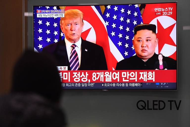 A TV de uma estação ferroviária em Seul mostra o ditador da Coréia do Norte, Kim Jong Un, com o presidente dos EUA, Donald Trump, durante sua primeira reunião em Hanói, em uma estação ferroviária em Seul