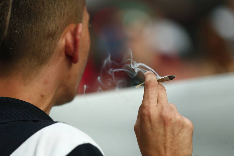 Jovem fuma um cigarro de maconha durante a Marcha da Maconha, na avenida Paulista, em São Paulo
