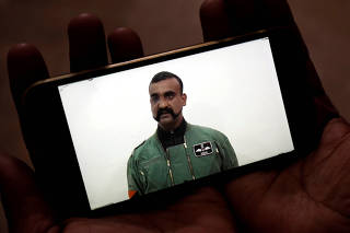 A man watches a statement of Indian Air Force pilot Abhinandan Varthaman on his mobile phone, released on twitter by the Ministry of Information & Broadcasting, in Karachi