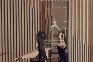 Kailee Combs, the vice president of fitness at Mirror, works out with some of the demos on one of the Mirror products in their showroom in New York.