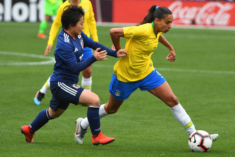 A meio-campista Andressa passa por marcadora durante jogo da seleção brasileira feminina de futebol
