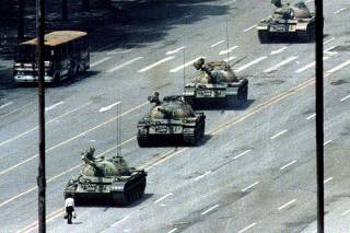 File photo of a Beijing citizen standing in front of tanks on the Avenue of Eternal Peace