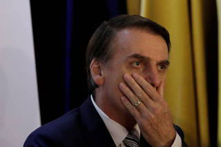 FILE PHOTO: Brazil's President Jair Bolsonaro reacts during an inauguration ceremony of the new president of the Parliamentary Agricultural Front (FPA) in Brasilia