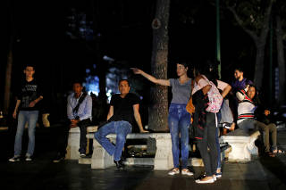 People gather at the park during a blackout in Caracas